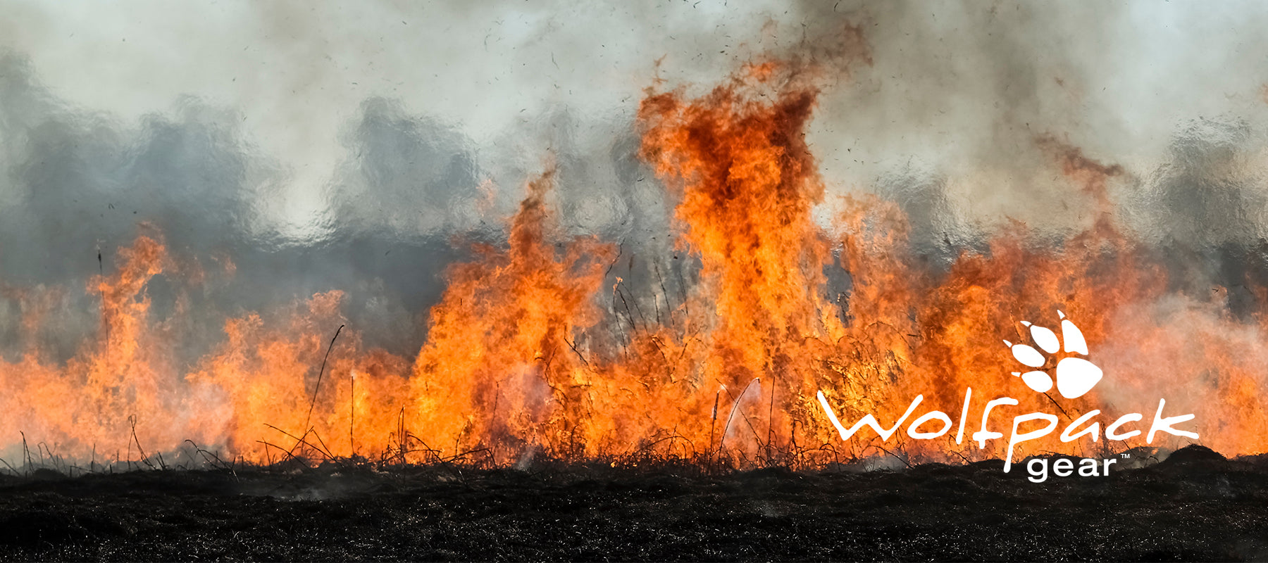 Wolfpack Gear™ - image of wildland grass fire with Wolfpack Gear™ Logo
